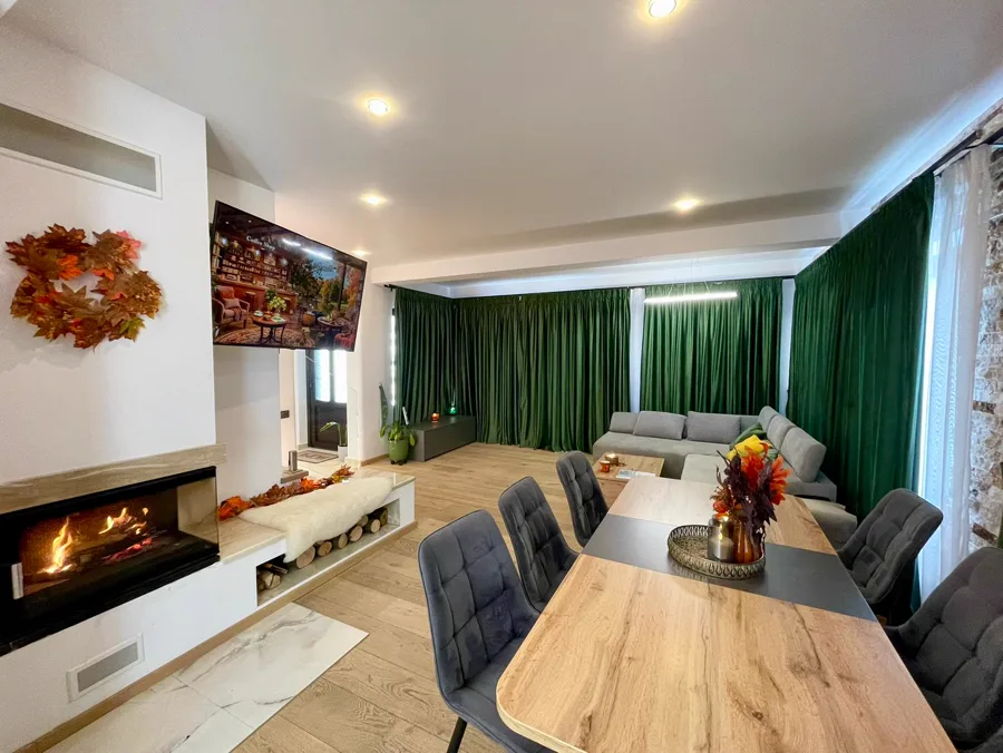 Spacious living room with fireplace and grey sofa — view from entrance